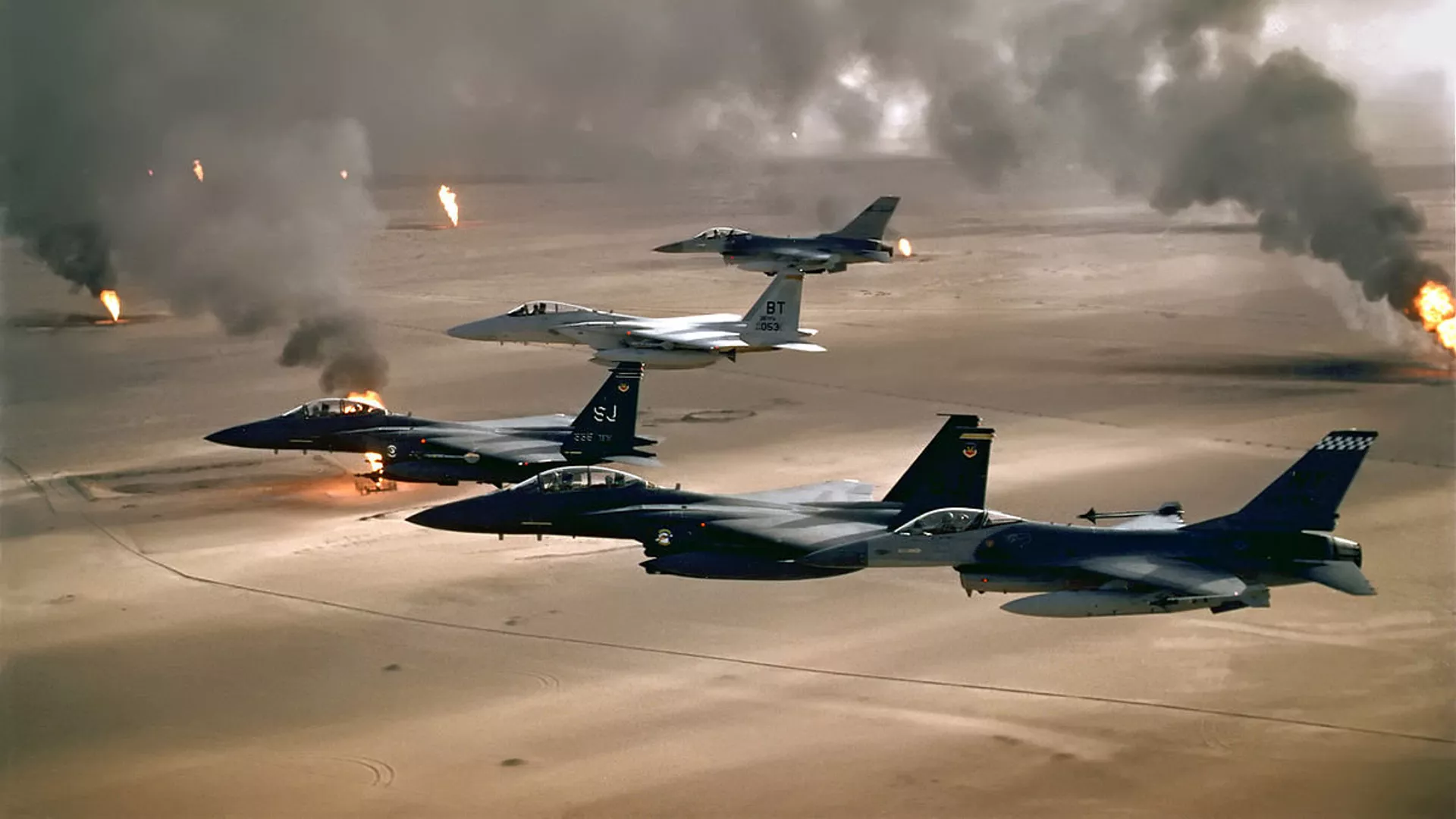 USAF aircraft of the 4th Fighter Wing (F-16, F-15C and F-15E) fly over Kuwaiti oil fires, set by the retreating Iraqi army during Operation Desert Storm in 1991