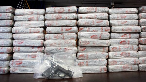 A firearm and 154 pounds of heroin worth at least $50 million are displayed at a Drug Enforcement Administration news conference. - اسپوتنیک افغانستان  