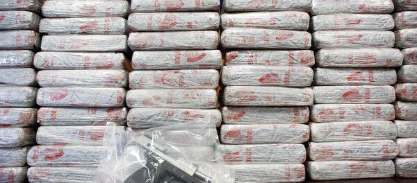 A firearm and 154 pounds of heroin worth at least $50 million are displayed at a Drug Enforcement Administration news conference. - اسپوتنیک افغانستان  