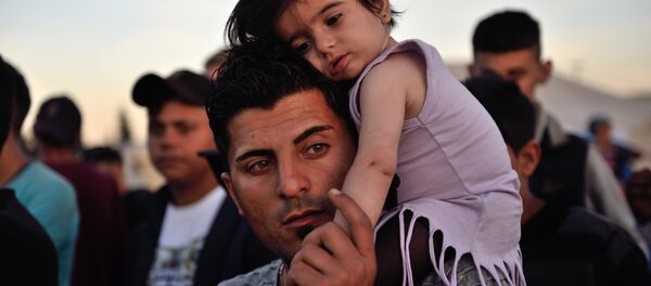 A man carries a child on his shoulders at the migrant and refugee makeshift camp near the village of Idomeni on the Greek-Macedonian border on April 16, 2016. A man carries a child on his shoulders at the migrant and refugee makeshift camp near the village of Idomeni on the Greek-Macedonian border on April 16, 2016. - اسپوتنیک افغانستان