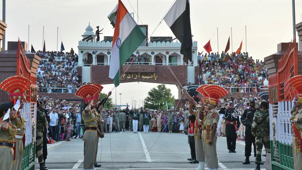 Indian and Pakistani flags are lowered during a daily retreat ceremony at the India-Pakistan joint border check post of Attari-Wagah near Amritsar, India, Tuesday, July 21, 2015 - اسپوتنیک افغانستان  