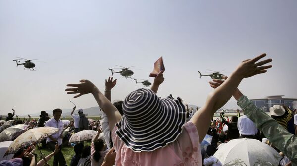 Зрители наблюдают за полетом вертолетов Хьюз 500 на первом авиашоу в Северной Корее - اسپوتنیک افغانستان  