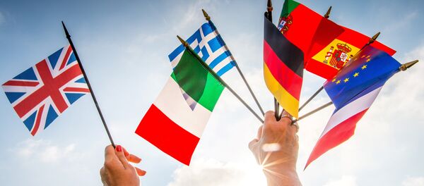 A person holds European country flags in an hand and a United Kingdom flag in another. - اسپوتنیک افغانستان  