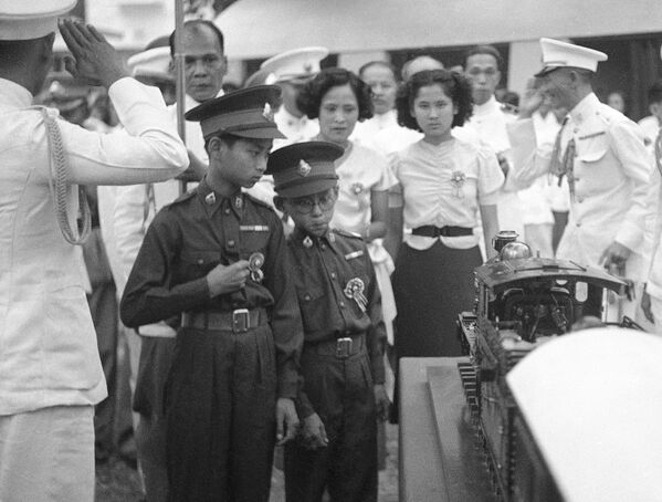 پادشاه 13 ساله سیامه اناندا و برادرش شاهزاده بومیپول در حال مشاهده نمونه ریل در بانکوک، سال 1938 - اسپوتنیک افغانستان  