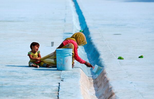 کودک توجه مادر خود را از کار در دهلی نو، هند منحرف مینماید - اسپوتنیک افغانستان  