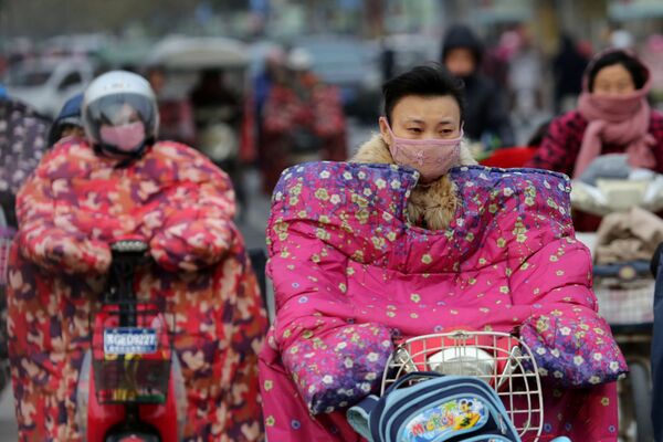 موتور سیکل سوار با لباس محلی خاص در برابر باد سرد در آب و هوای سرد در چین - اسپوتنیک افغانستان  